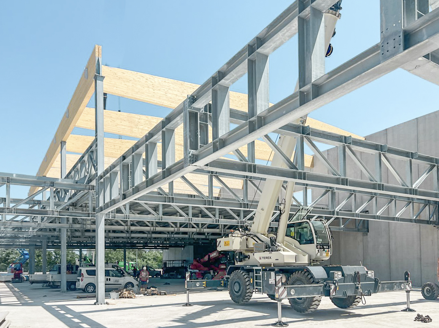 Cantiere Garden Frutta: montaggio di grandi strutture a traliccio in acciaio zincato e travi in legno lamellare con autogru, carpenteria Fratelli Gelmini.